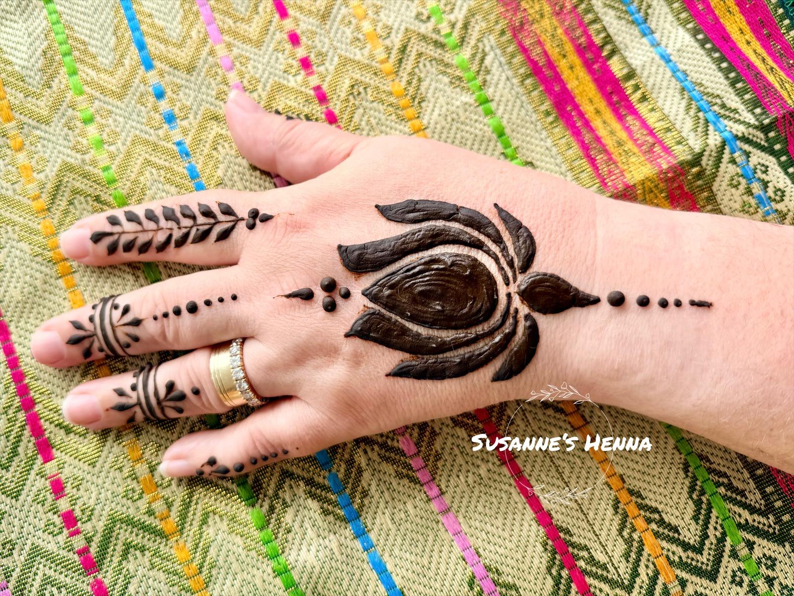 Kleines florales Henna-Design auf dem Handrücken